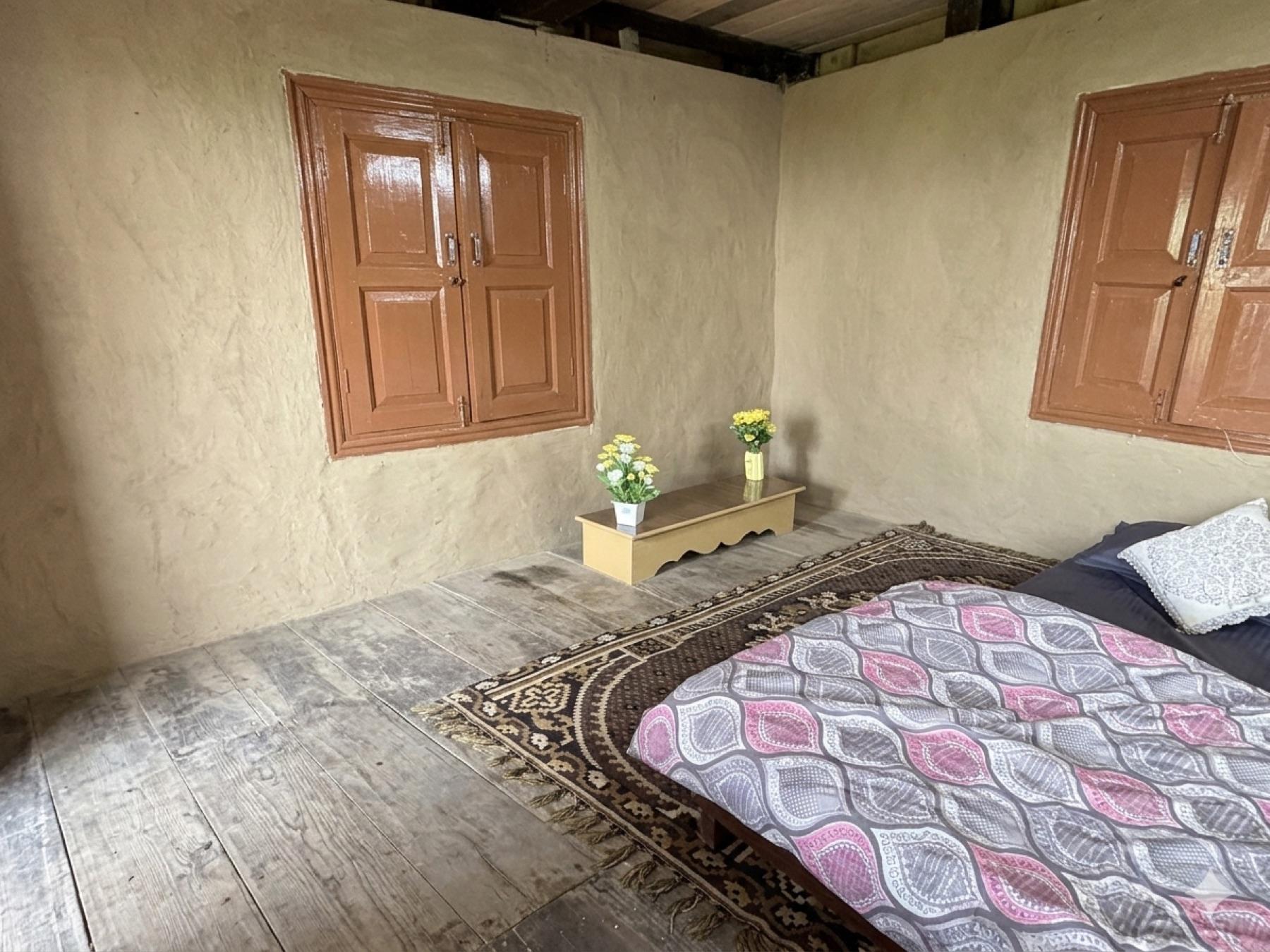 Hand-plastered mud walls and deodar beams in a House of Hulda guest room